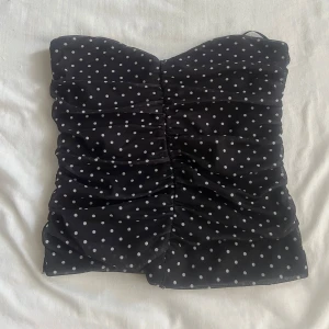 Svart prickig tubtopp från BikBok - Super snygg prickig tub topp från bil bok super snygg till fest och att ha till skolan #stockholmstil #prickig #sommar #vår #höst #skola #fest #festtopp #snygg #söderstil #baggyjeans #lågmidjadejeans 