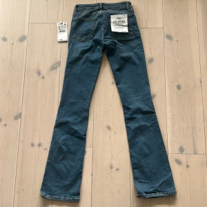 Zara low rise slim bootcut jeans blå - HELT OANVÄNDA blå jeans från Zara i modellen low rise slim bootcut. Jeansen har fem fickor, låg midja och utsvängda ben med slim passform upptill. Tillverkade i stretchigt denim för extra komfort. 
