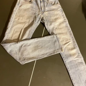 Levi's 511 ljusblå jeans straight fit - Klassiska Levi's 511 jeans i ljusblå tvätt med rak passform. Jeansen har fem fickor, knappgylf och den ikoniska läderpatchen bak i midjan. Tillverkade i slitstarkt bomullsjeansmaterial, perfekta för en avslappnad och tidlös look.