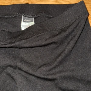 Svarta bootcut byxor från Gina Tricot - Svarta bootcut byxor från Gina Tricot med hög midja och stretchigt material. Snygg passform som sitter tajt upptill och släpper ut i benen. Perfekta för dig som gillar en klassisk och stilren look.