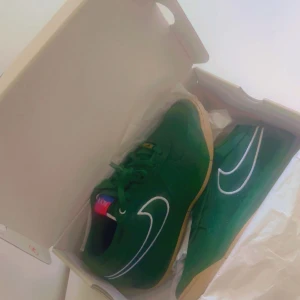 Gröna Nike sneakers med vit swoosh - Säljer ett par gröna Nike sneakers med vit swoosh och gummisula. Skorna har snörning och en färgglad detalj på plösen. Perfekta för dig som vill sticka ut med en unik färg på fötterna.