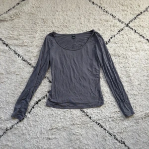 Grå långärmad topp från SHEIN XS - En enkel och stilren grå långärmad topp från SHEIN i storlek XS Petite. Toppen har rundad halsringning och är tillverkad i mjuk bomullsmix, perfekt att matcha med jeans eller kjol.