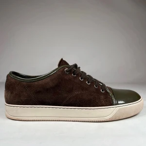 Lanvins cap toe  - Snygga lanvins i mörkbrunt mocka med olivgröna lackade tår och detaljer. Skorna har snörning och en vit platt sula som ger en clean look. Perfekta för dig som gillar en stilren men ändå unik vibe. Bara skorna medföljer självklart äkta storlek 44 uk 10