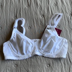 Oanvänd Vit spets-bh Iris från Abecita 70C - Säljer en vit bh från Abecita, modell Iris, i storlek 70C. Bh:n har bygel, justerbara axelband och fina spetsdetaljer längs sidorna och bak. Materialet är mjukt och bekvämt. Skulle säga att den är en storlek mindre i kupan🫶🏻