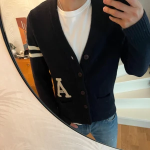 Cardigan från Abercrombie & Fitch - En fet blå cardigan från abercrombie & fitch med riktigt snygga detaljer. Skicket är bra och storleken är M. 