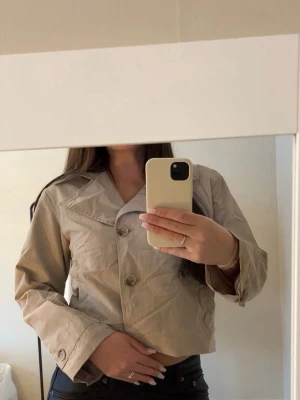 Beige trenc coat  - Utsåld beige trenchcoat från Cubus barn. Använd fåtal gånger så som ny. Nytvättad därav skrynklig. Nypris 399kr. Storlek 164, sitter som XS. Säljer då jag har en till. Tryck gärna på köp nu. 