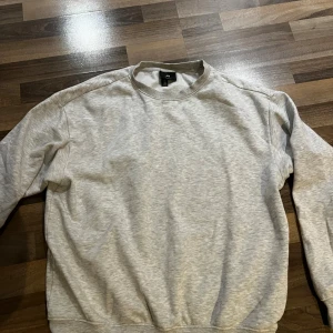 Ljusgrå sweatshirt från H&M - En basic ljusgrå sweatshirt från H&M med rundad hals. Tröjan har en avslappnad passform och är skön att ha på sig. Storleken är M. Priset går att diskutera👍