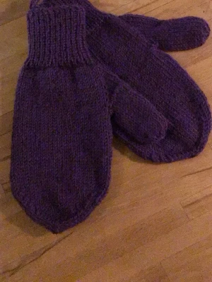 Lila stickade tumvantar - Mysiga lila stickade tumvantar med bred mudd. Perfekta för kalla dagar och ger en skön känsla. Klassisk modell utan mönster eller detaljer. Passar dig som vill ha något enkelt och snyggt.