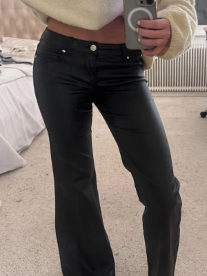 Svarta skinnbyxor från ONLY - Säljer ett par supersnygga svarta skinnbyxor i skinnimitation från ONLY. Bootcut-modell med utsvängda ben. Storlek 30/XS. Väldigt bekväma och passar perfekt till både vardag och fest.💕💕