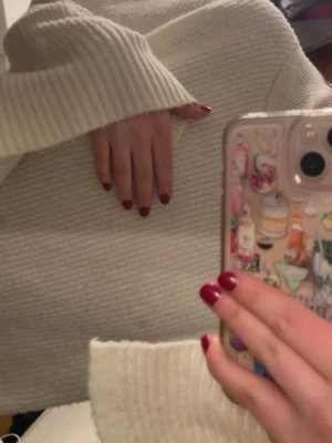 Vit oversized stickad tröja - Mysig vit stickad tröja med oversized passform och höga ribbade muddar vid ärmslut och hals. Tröjan har en rak modell och är perfekt för lager-på-lager. Materialet ser ut att vara mjukt och tjockt, vilket ger en avslappnad och trendig look. Storlek s men är som en m