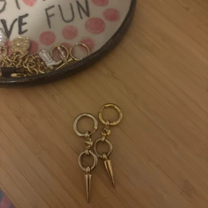 Guldiga örhängen med spikes - Säljer ett par statement örhängen i guld från Syster P, orginalpriset är 2300kr men säljer för 850kr pågrund av att dem är använda💞