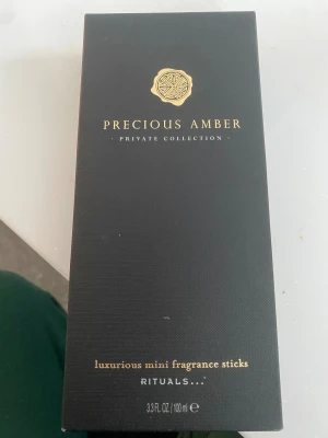 Precious Amber doftpinnar Rituals - Lyxiga mini doftpinnar från Rituals Private Collection i doften Precious Amber. Förpackningen är svart med gulddetaljer och innehåller 100 ml. Doften har inslag av enbär, kardemumma, ylang ylang, patchouli, vetiver och bärnsten.