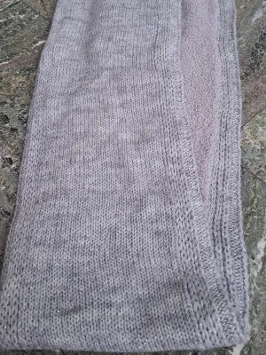 Ljusgrå stickad halsduk - Mysig ljusgrå halsduk i stickat material med mjuk, fleece-liknande insida. Enkel design utan mönster och i rektangulär form. Perfekt för att hålla värmen under kyliga dagar.