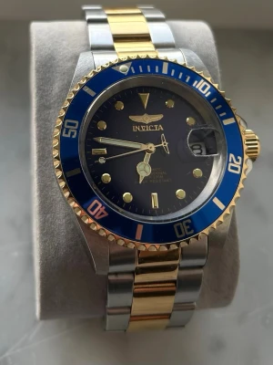 Invicta Pro Diver Automatic (NH35) – Blå/Guld – 200m  -  Säljer min Invicta Pro Diver Automatic (ej quartz/batteri). Tvåton stål/guld med blå tavla och blå bezel. Klassisk dykardesign med 200m vattentäthet och automatisk Seiko NH35-rörelse (24 jewels).  Specifikationer: 	•	40 mm boett 	•	Automatisk (NH35) 	•	Skruvad krona 	•	Datum med förstoringsglas 	•	200m water resistant 	•	Original stållänk