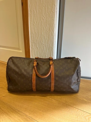 Louis Vuitton Keepall 55 - Säljer en klassisk brun weekendbag från Louis Vuitton med ikoniskt monogrammönster och detaljer i läder. Storlek 55 och i fint använt skick.