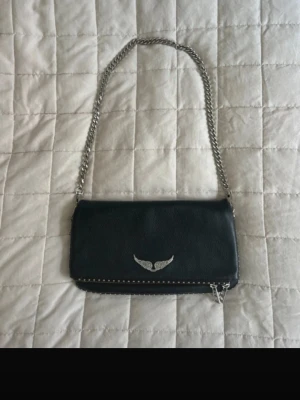 Svart axelväska med silverkedja - Snygg svart zadig & Voltaire väska med silver kedja. Det finns två kedjor som man kan ta av och på, en längre och en kortare.