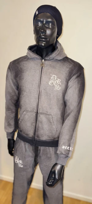 Decrese Sweden 🇸🇪 Hoodie – Svart/Grå, vit brodyr (Large) - Decrese Sweden 🇸🇪 Hoodie – Svart/Grå, vit brodyr (Medium) Hoodie i mjuk bomullsblandning med lätt stretch och stentvättad finish. Vita broderade detaljer ger ett stilrent streetwear-uttryck.•     Axel: 54 cm 	•	Bröst: 54  cm 	•	Längd: 70 cm 	•	Ärmar: 61 cm 	•	2 fickor 	•	Vit logga fram, svart brodyr bak, svart drake på huvan    • Bomull med stretch, stentvättad finish  Finns i flera storlekar, skriv vilken du vill ha. 📦 Skickas inom 1–2 dagar. ⚠️ Köparen står för returfrakt.  