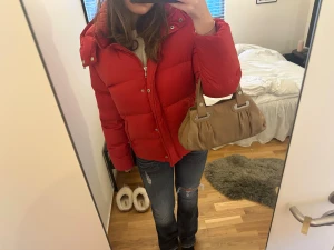 Röd pufferjacka från Polo Ralph Lauren - Säljer min snygga vinterjacka från  Ralph lauren  då den tyvärr inte kommer till användning längre. Fodret är 100% dun så den är riktigt varmt på vintern. I mycket god skick 