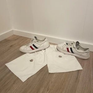 Moncler skor - Vita mocler skor med medföljande dustbags. Storlek 43 gott skick men små skador se bilder. För frågor skriv privat!