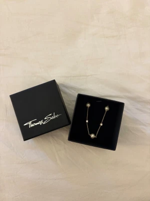 Thomas Sabo pärlhalsband i silver - Snyggt halsband från Thomas Sabo med tunn silverkedja och tre vita pärlor samt små glittrande stenar. Halsbandet kommer tyvärr inte till användning längre. Nypris 1219 kr. 