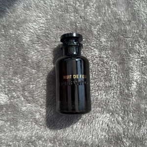 Louis Vuitton Nuit De Feu parfym - Exklusiv parfym från Louis Vuitton, Nuit De Feu. Flaskan är svart och elegant med guldtext och rundad form. Kommer i original vit cylinderförpackning med Louis Vuitton-logga. Perfekt för dig som gillar lyxiga dofter och snygg design. Boxen har defekt därav lägre pris. 