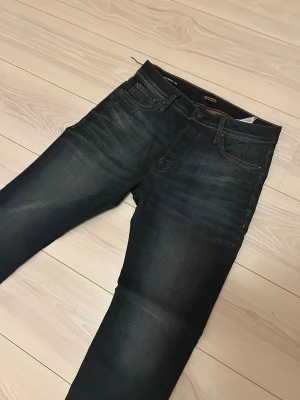 Mörkblå jeans från Jack & Jones - Ett par helt oanvända snygga jeans från Jack & Jones. Aldrig använda så att helt nya, man kan se en snodd av en tag som är kvar på bild 3. W30. Slim jeans