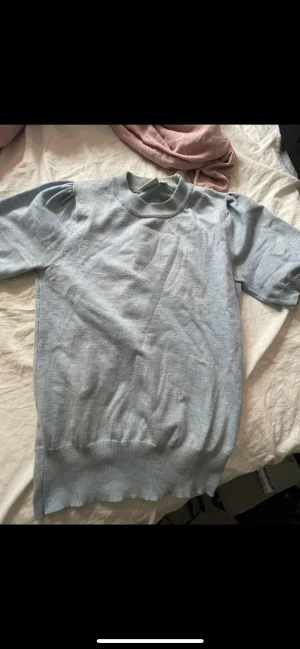 Ljusblå stickad kortärmad tröja - Supersöt ljusblå stickad tröja med puffiga korta ärmar från saint tropez . Perfekt för dig som gillar en enkel men ändå lite extra look. Mjuk och skön känsla tack vare det stickade materialet. Passar till jeans eller kjol för en chill vibe. Nästan aldrig använd 