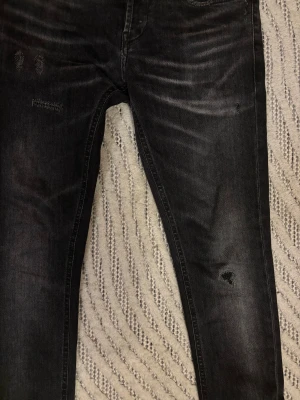 Dondup jeans - Säljer dessa riktigt schyssta ”ripped” mörkgrå dondup jeans. Byxorna är endast använda ett fåtal gånger. Köptes för runt 3000kr. Orginal lapp medföljer. 