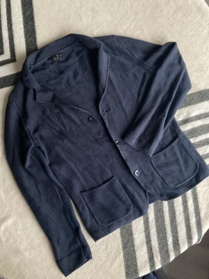 Massimo Dutti Cardigan - Snygg mörkblå cardigan jacka från Massimo Dutti i exklusiv bomull. Jackan har två framfickor, klassisk krage och stängs med knappar. Perfekt för dig som gillar stilrena och bekväma plagg med en chill vibe.