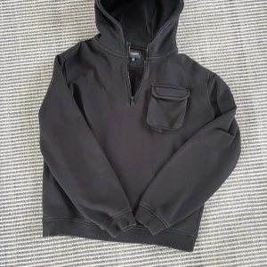 Lyle and scott - Svart hoodie från Lyle & Scott med huva, halv dragkedja och en praktisk ficka på bröstet. Ärmen har en gul logga som detalj. Perfekt för dig som gillar en stilren och sportig look. Passar till allt pris kan diskuteras vid snabb affär 