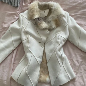 Vit pälsjacka från Vila, storlek S - Säljer en superfin vit pälsjacka från Vila i storlek S. Jackan har fluffig fuskpäls på krage, ärmslut och insida, samt snygga sömdetaljer på utsidan. Den är figursydd och har en lyxig känsla, perfekt för dig som vill sticka ut i vinter. Saknar tyvärr knapparna💕💕