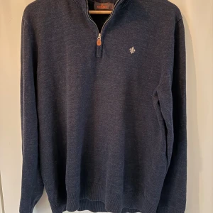 Mörkblå stickad half zip från Morris - Snygg mörkblå stickad tröja från Morris med half zip och ribbad krage. Tröjan har en liten broderad logga på bröstet. Sparsamt andvänd men har krymt lite i tvätten så skulle säga att den passar L. Inga syndliga defekter, vi frågor osv så får du gärna höra av dig 🤩