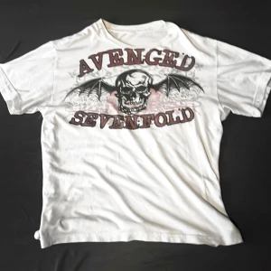 Super rare Avenged Sevenfold t shirt (2007) - Säljer en rare tshirt från bandet Avenged Sevenfold. För er som minst det så hade Andy Biersack från bandet Black Veil Brides mer känd som Andy Sixx då under Myspace eran på sig en liknande t shirt. Eftersom den är så rare går den för ett högt pris.  