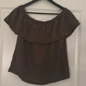 Offshoulder topp med volang - Gullig mörkgrön offshoulder topp med volang. Går att ha med båda armarna under volangen men även ha one shoulder. 