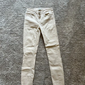 Beige skinny jeans från ONLY - Snygga beige skinny jeans från ONLY med klassisk femficksdesign och dragkedjegylf. Byxorna har smal passform och är tillverkade i mjuk bomullsblandning. Perfekta att matcha med en oversized hoodie eller en enkel t-shirt.