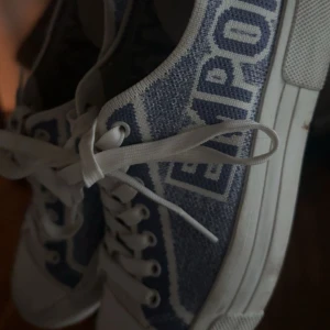 Blåvita sneakers från Armani - Snygga sneakers från Armani i blått och vitt med tydlig logga längs sidan. Helt slutsåld!! Bra sick, lite smutsig längst fram men kan lätt tvättas bort💕💕