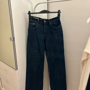Mörkblå midrise jeans från Zara, strl 38 - Snygga mörkblå jeans från Zara.  Jeansen är midrise har raka ben och normal passform, med kontrastsömmar och knappgylf. Perfekta till sneakers eller boots och funkar året runt. Materialet är tåligt denim i bomull.💞💞