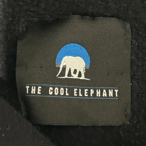 Svart hoodie med röda drakar - Svart hoodie från The Cool Elephant med två röda drakar broderade på bröstet. Tröjan har huva med snörning och en stor magficka. Perfekt för dig som gillar streetstyle och vill sticka ut med coola detaljer.