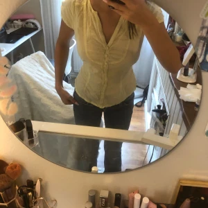 Ljusgul blus - Supersöt ljusgul blus från H&M med korta ärmar och v-ringning. Blusen har små prickar i tyget, klädda knappar framtill och en lätt figursydd passform. Perfekt för vår och sommar när du vill ha en fräsch och luftig look💗💗💗