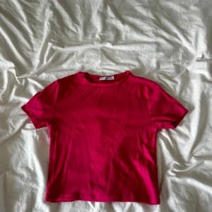 Rosa t-shirt från Stradivarius - En enkel och snygg rosa t-shirt från Stradivarius i storlek S. Modellen är klassisk med rund halsringning och korta ärmar. Perfekt att matcha med jeans eller kjol för en chill look. Bra skick!