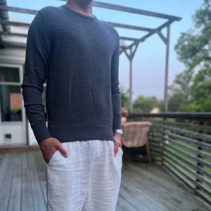 Mörkgrå merinoullströja från Uniqlo - Snygg och stilren mörkgrå tröja från Uniqlo i mjuk merinoull. Klassisk rund halsringning och långärmad modell som passar perfekt till lager-på-lager. Enkel design som funkar till många olika outfits.