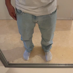 Ljusblå Lee jeans W34 L32 - Säljer ett par ljusblå jeans från Lee i klassisk straight fit. Jeansen har fem fickor, normal passform och är tillverkade i slitstarkt bomullstyg. Perfekta för dig som gillar en avslappnad och tidlös look. Storlek W34 L32. Hör av er om ni har några frågor det går alltid och diskutera priset