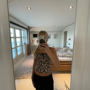 Leopardmönstrad linnetopp med spets - Säljer en leopardmönstrad linnetopp med tunna axelband och söt svart spetskant upptill. Toppen har en liten rosett framtill och är croppad i modellen💗