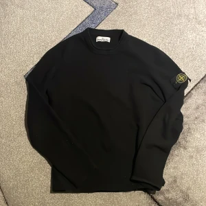 ÄKTA Stone Island tröja - Svart långärmad tröja från Stone Island med klassisk patch på vänster ärm. Tröjan har en enkel och clean design med rund halsringning. Tröjan är använd ett bra tag men har inte några synliga defekter. Äktenhetsbevis finns 7/10 skick Ord pris: 4899 Mitt pris 1899 L men passar M