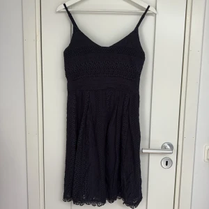 Mörkblå spetsklänning från ONLY - Supersöt mörkblå kortklänning från ONLY med smala axelband och v-ringning. Klänningen har ett fint spetsmönster över hela. Perfekt sommarklänning som passar till allt!