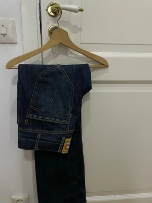 Levi's 511 straight slim mörkblå jeans - Säljer ett par klassiska Levi's 511 straight slim jeans i mörkblå tvätt. Jeansen har raka ben, fem fickor och tydliga kontrastsömmar. Materialet är slitstarkt denim och de har den ikoniska Levi's-lappen bak. Perfekt för dig som gillar tidlös stil. Jeansen har en vintage-gul tab. 