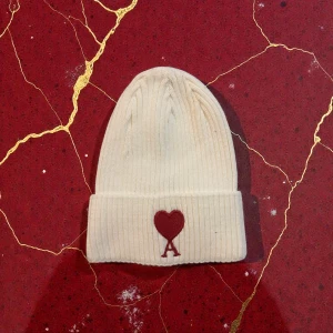 Ami mössa - Mössa från Ami i ljus beige med röd hjärtbroderi, inte en väst.