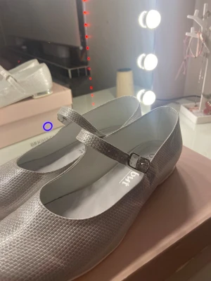 Silvriga ballerina med spänne från Gamabut  - Säljer ett par silvriga ballerina med rund tå och justerbart spänne över foten. Köpte i polen till bröllop ( Använda en gång ), jätte fina 💕