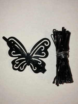 Svart fjärilsformad hårklämma - Säljer en svart hårklämma i form av en fjäril tillsammans med 22 oanvända svarta hårnålar. Klämman har snygga utskärningar och ger en cool touch till frisyren. Perfekt för att fixa håret snabbt och enkelt. Frakten är ca 22-100kr beroende på vikten på produkten . Kontakta mig om du vill köpa.