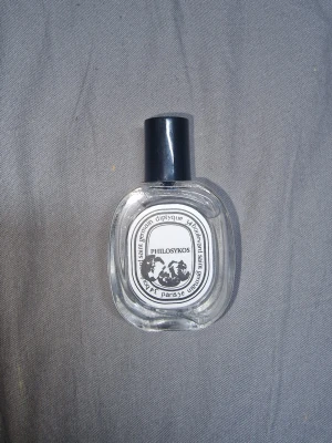 Philosykos Eau de Toilette 10ml - Upptäck Diptyque Philosykos i smidig 10 ml flaska. Ingredienser: alcohol denat., aqua, parfum, geraniol, linalool, citronellol, limonene, eugenol, benzyl alcohol, citral, isoeugenol, farnesol, BHT. Tillverkad i Paris. Perfekt för dig som vill ha något unikt och stilrent.